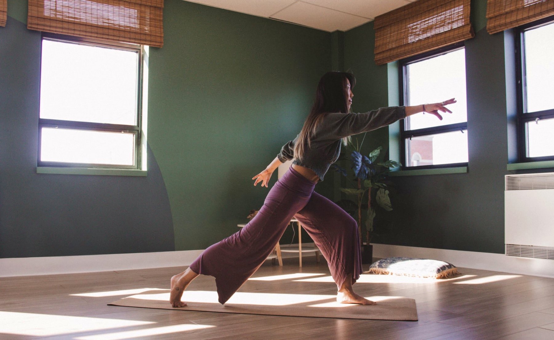 Groupe en posture de yoga dans un studio lumineux.