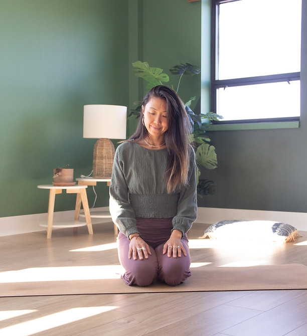 Letitia Rose agenouillée sur un tapis de yoga dans un espace de pratique lumineux