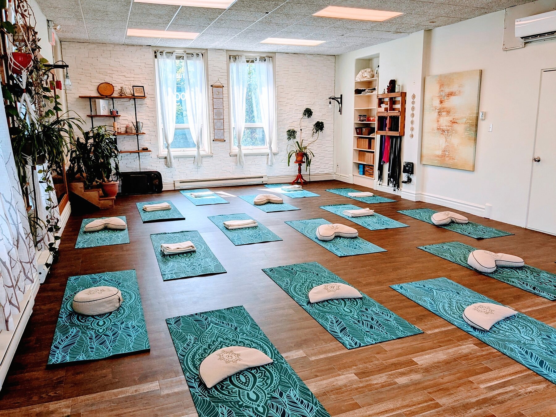 Studio Karma Yoga Saguenay préparé pour une pratique de groupe avec tapis, coussins et lumière naturelle.