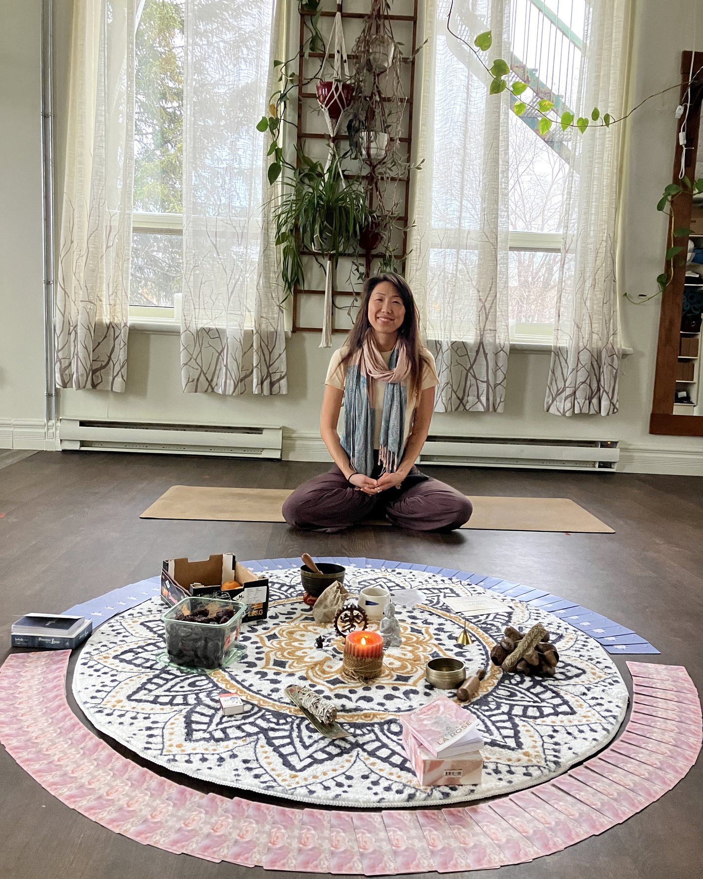 Letitia Rose in a bright private session space with a mat, plants and a practice circle.